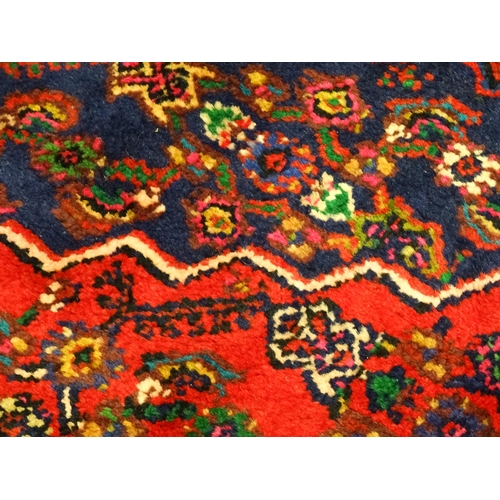 1316 - Carpet / Rug : A North West Persian Hamadan carpet the red ground decorated with cream vignette with... 