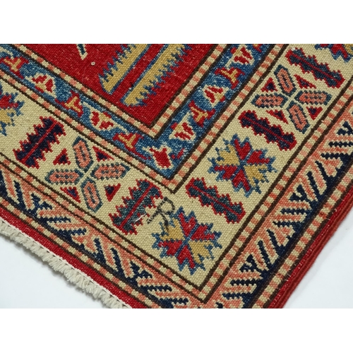 1317 - Carpet / Rug : A red ground runner decorated with repeating geometric motifs within banded geometric... 