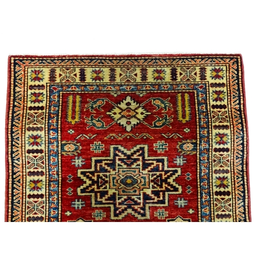 1317 - Carpet / Rug : A red ground runner decorated with repeating geometric motifs within banded geometric... 