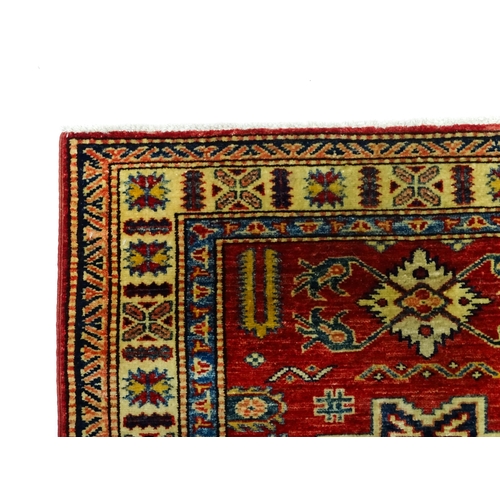 1317 - Carpet / Rug : A red ground runner decorated with repeating geometric motifs within banded geometric... 