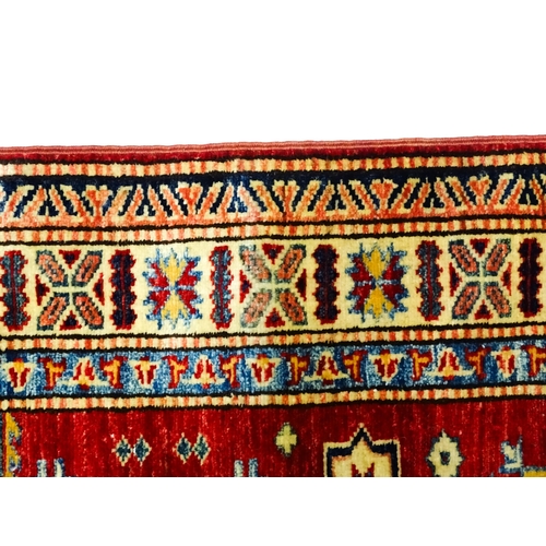 1317 - Carpet / Rug : A red ground runner decorated with repeating geometric motifs within banded geometric... 