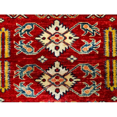 1317 - Carpet / Rug : A red ground runner decorated with repeating geometric motifs within banded geometric... 