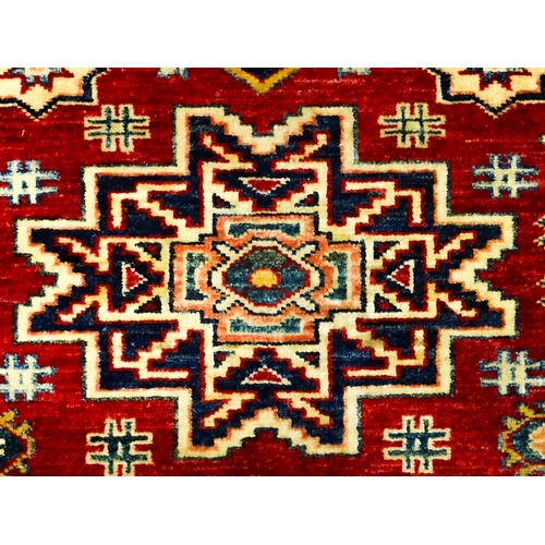 1317 - Carpet / Rug : A red ground runner decorated with repeating geometric motifs within banded geometric... 