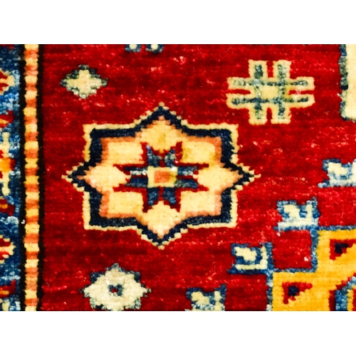 1317 - Carpet / Rug : A red ground runner decorated with repeating geometric motifs within banded geometric... 