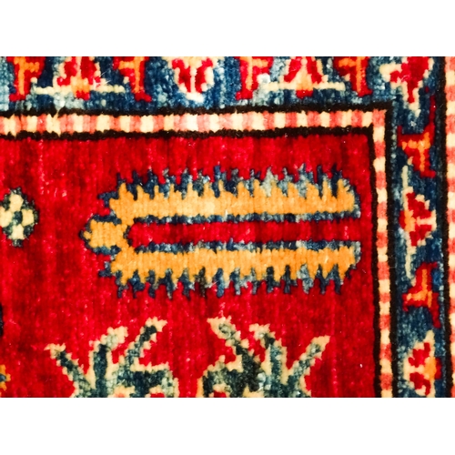 1317 - Carpet / Rug : A red ground runner decorated with repeating geometric motifs within banded geometric... 