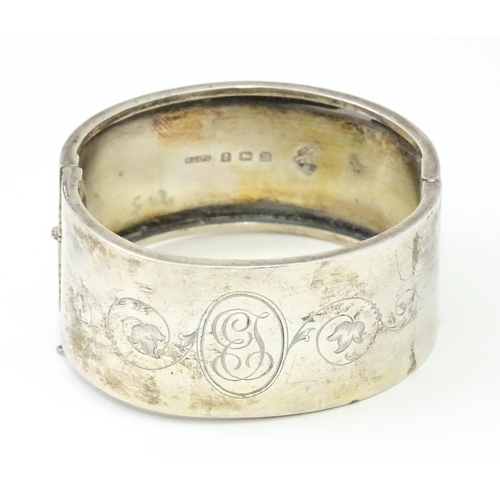 585 - A silver bangle formed bracelet with engraved decoration. Hallmarked Birmingham 1936 maker Federated... 