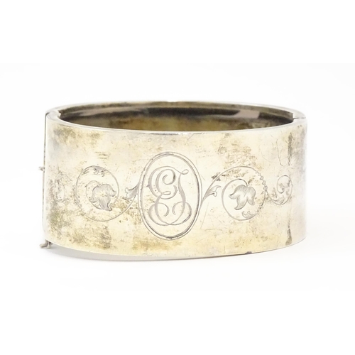 585 - A silver bangle formed bracelet with engraved decoration. Hallmarked Birmingham 1936 maker Federated... 