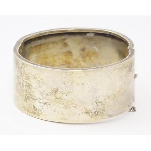 585 - A silver bangle formed bracelet with engraved decoration. Hallmarked Birmingham 1936 maker Federated... 