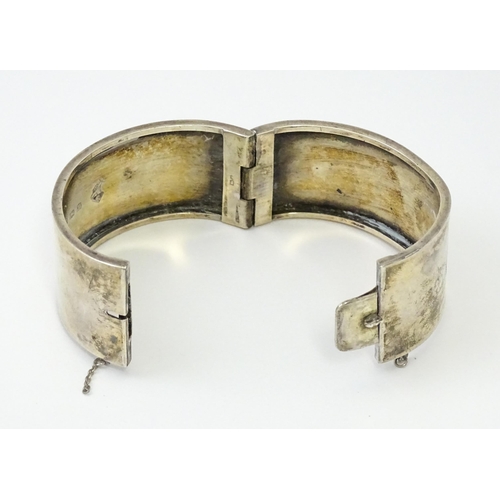 585 - A silver bangle formed bracelet with engraved decoration. Hallmarked Birmingham 1936 maker Federated... 