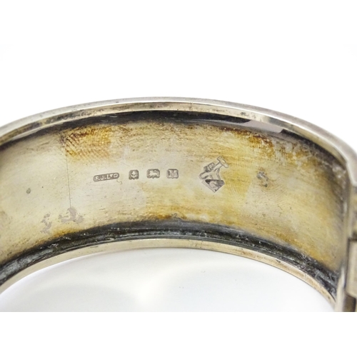 585 - A silver bangle formed bracelet with engraved decoration. Hallmarked Birmingham 1936 maker Federated... 