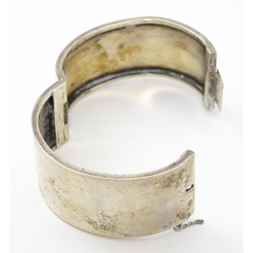 585 - A silver bangle formed bracelet with engraved decoration. Hallmarked Birmingham 1936 maker Federated... 
