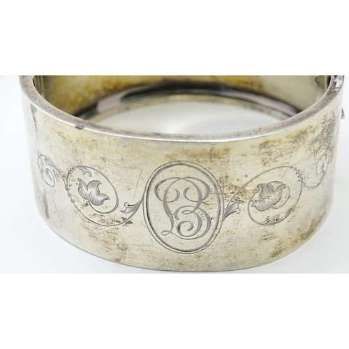 585 - A silver bangle formed bracelet with engraved decoration. Hallmarked Birmingham 1936 maker Federated... 