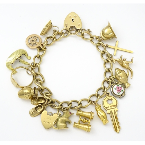 604 - A 9ct gold charm bracelet set with various 9ct gold and yellow metal charms to include penguin, iron... 