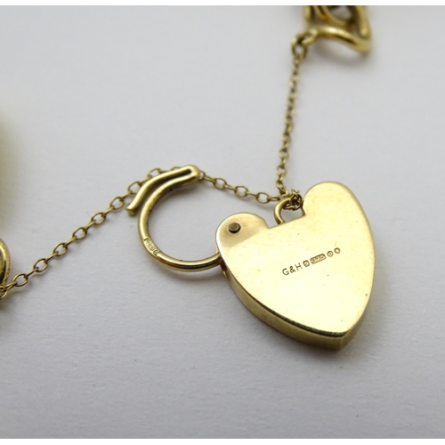 604 - A 9ct gold charm bracelet set with various 9ct gold and yellow metal charms to include penguin, iron... 