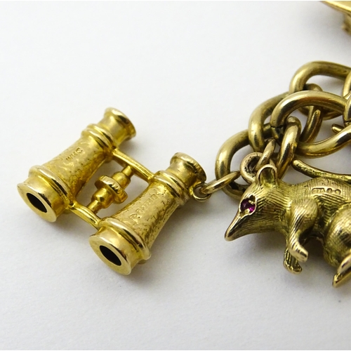 604 - A 9ct gold charm bracelet set with various 9ct gold and yellow metal charms to include penguin, iron... 