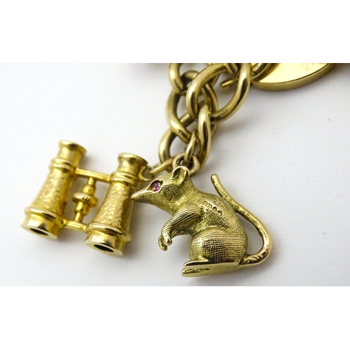 604 - A 9ct gold charm bracelet set with various 9ct gold and yellow metal charms to include penguin, iron... 