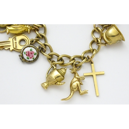 604 - A 9ct gold charm bracelet set with various 9ct gold and yellow metal charms to include penguin, iron... 