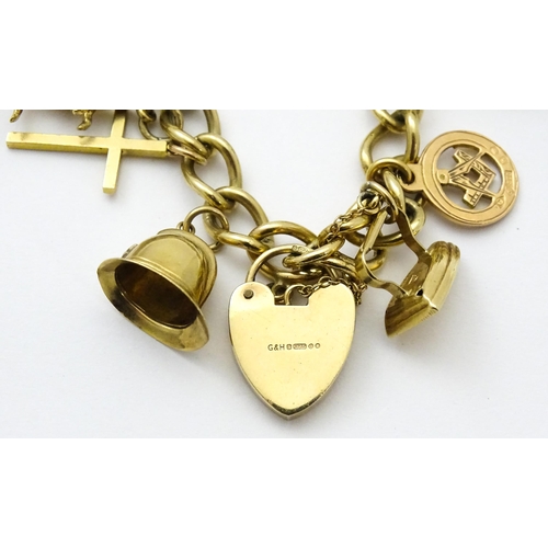 604 - A 9ct gold charm bracelet set with various 9ct gold and yellow metal charms to include penguin, iron... 