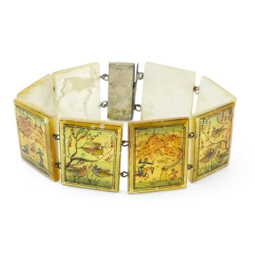 734 - An Indian bracelet with mother of pearl panels decorated  with scenes depicting figures, birds etc.