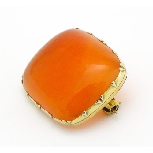 750 - A brooch set with orange carnelian within a yellow metal mount.  Approx. 1