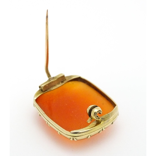 750 - A brooch set with orange carnelian within a yellow metal mount.  Approx. 1