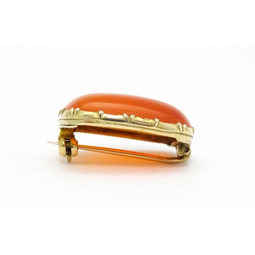 750 - A brooch set with orange carnelian within a yellow metal mount.  Approx. 1