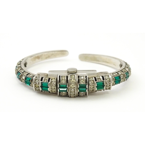 808 - A Swiss bangle formed cocktail watch set with white and green stones, the central section  hinging o... 