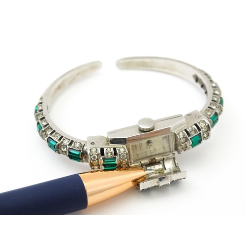 808 - A Swiss bangle formed cocktail watch set with white and green stones, the central section  hinging o... 