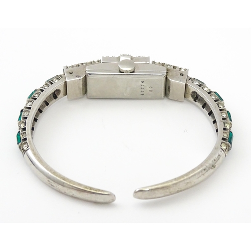 808 - A Swiss bangle formed cocktail watch set with white and green stones, the central section  hinging o... 