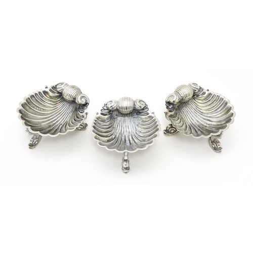 262 - Three Victorian silver salts of scallop shell form raised on three stylised dolphin feet, hallmarked... 