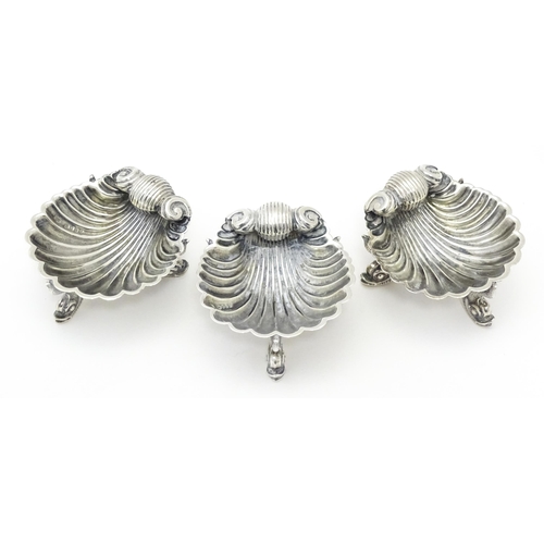 262 - Three Victorian silver salts of scallop shell form raised on three stylised dolphin feet, hallmarked... 