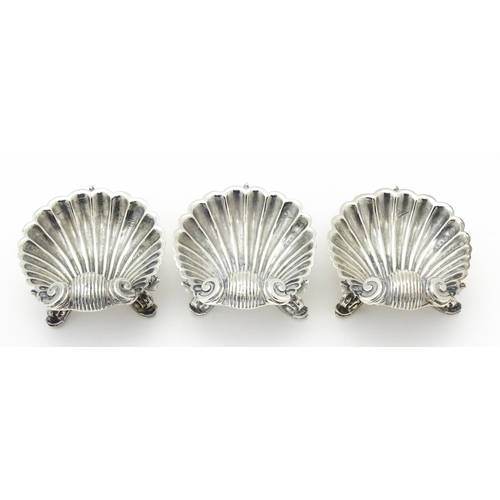 262 - Three Victorian silver salts of scallop shell form raised on three stylised dolphin feet, hallmarked... 