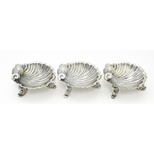 262 - Three Victorian silver salts of scallop shell form raised on three stylised dolphin feet, hallmarked... 