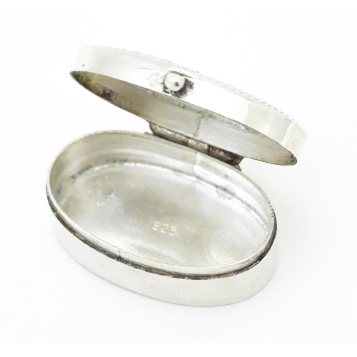 270 - A .925 silver pill box of oval form with engraved decoration and hinged lid. Approx 1 1/4