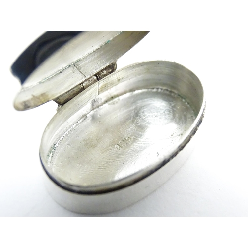 270 - A .925 silver pill box of oval form with engraved decoration and hinged lid. Approx 1 1/4