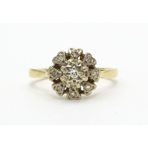 551 - An 18ct gold ring with nine illusion set diamonds in a floral setting. Ring size approx. K 1/2