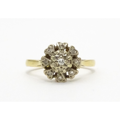 551 - An 18ct gold ring with nine illusion set diamonds in a floral setting. Ring size approx. K 1/2