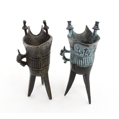 1048 - Two Chinese cast jue / ceremonial wine vessels with single zoomorphic handle, spout and raised on tr... 