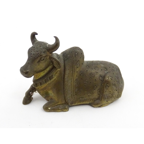 1049 - Three assorted items to include an Indian cast brass Nandi idol modelled as a recumbent bull with st... 