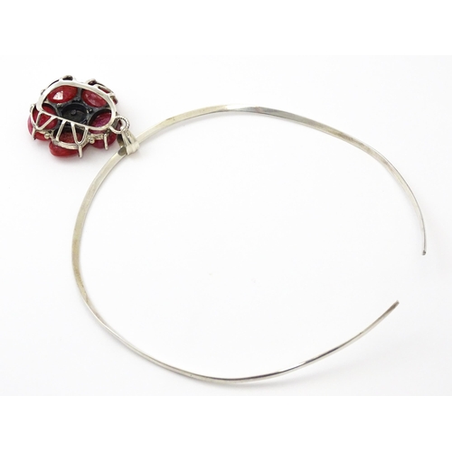 753 - A silver necklace of choker form with rose formed pendant set with red stones. The pendant approx 1 ... 