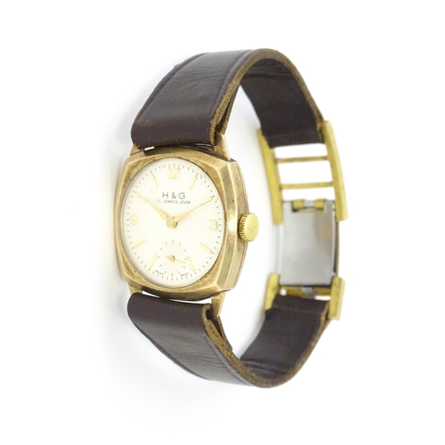 807 - A 9ct gold cased wristwatch, the dial signed H & G, with brown leather strap. Watch approx. 1