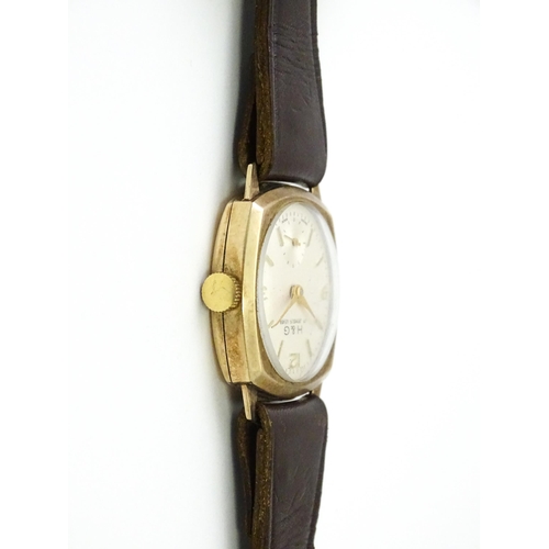 807 - A 9ct gold cased wristwatch, the dial signed H & G, with brown leather strap. Watch approx. 1