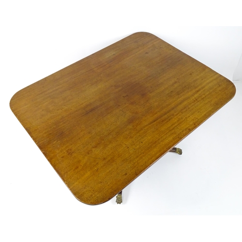 1440 - A Victorian mahogany breakfast table with an oblong tilt top above a turned pedestal and four sabre ... 