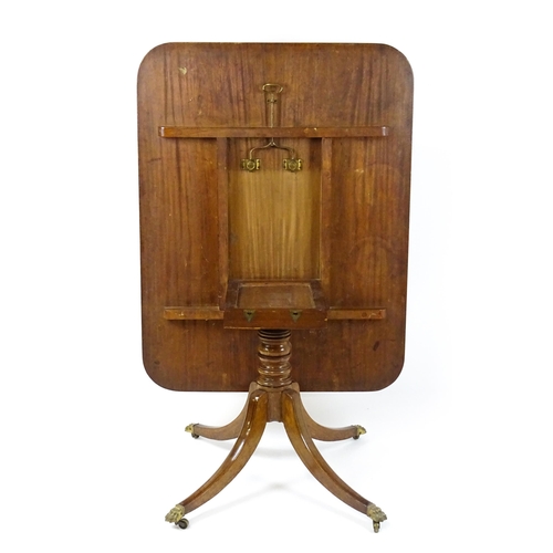 1440 - A Victorian mahogany breakfast table with an oblong tilt top above a turned pedestal and four sabre ... 