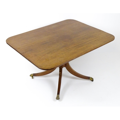 1440 - A Victorian mahogany breakfast table with an oblong tilt top above a turned pedestal and four sabre ... 