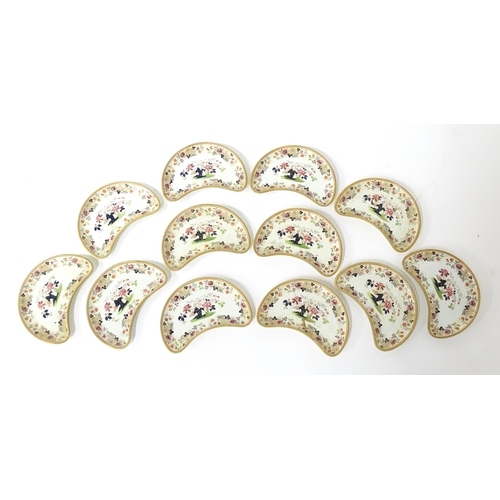 79 - Twelve Davenport crescent shaped salad dishes with floral and foliate decoration. Marked under. Appr... 