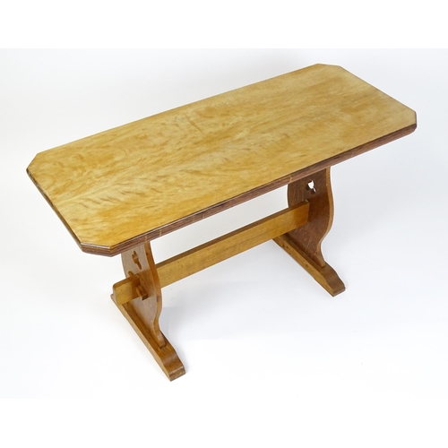 1441 - An early 20thC oak trestle table with a canted table top above two pieced platforms united by a rect... 