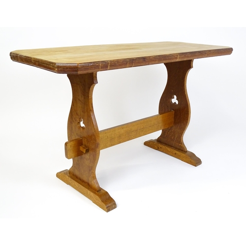 1441 - An early 20thC oak trestle table with a canted table top above two pieced platforms united by a rect... 