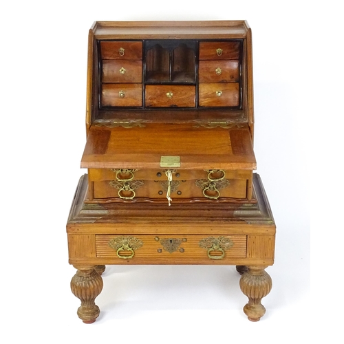 1442 - A 20thC Anglo - Indian bureau on stand with a fall front opening to show fitted drawers and pigeon h... 