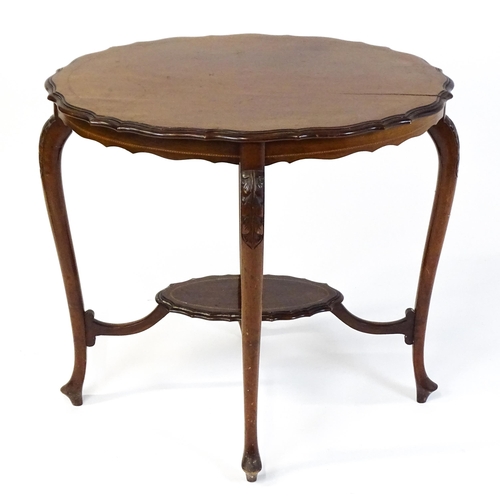 1472 - An Edwardian mahogany occasional table with a shaped inlaid top above four carved cabriole legs unit... 